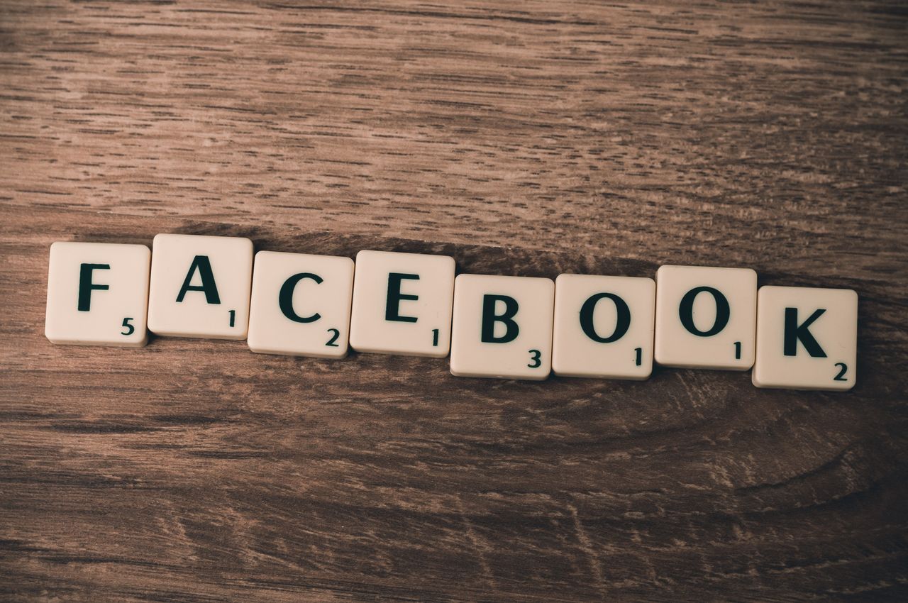 services-01 Des lettres de Scrabble formant Facebook sur un fond en bois, illustrant les réseaux sociaux.