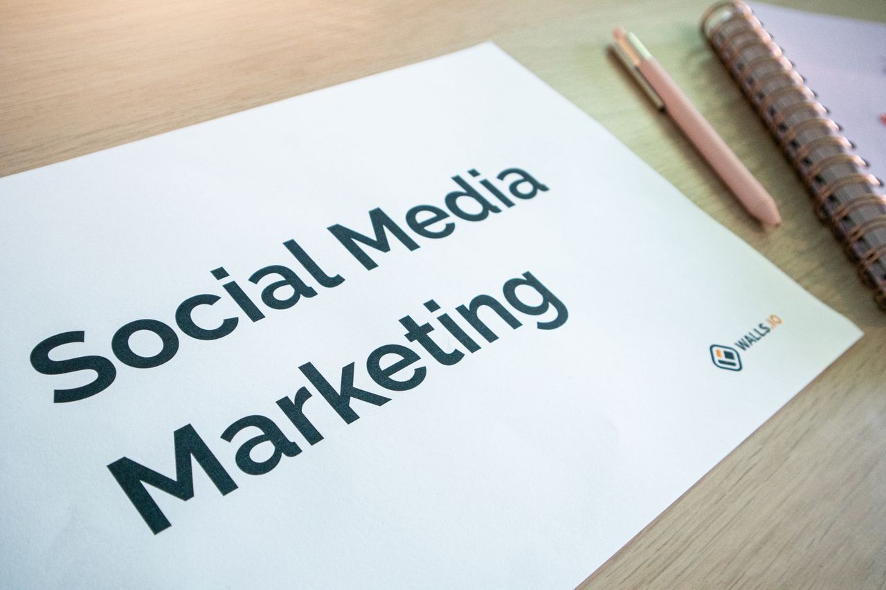 services-03 Close-up of a social media marketing document on a desk with a pen and notebook.